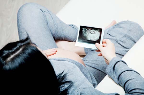 Mor slapper af med baby i maven og kigger på scanningsbilleder