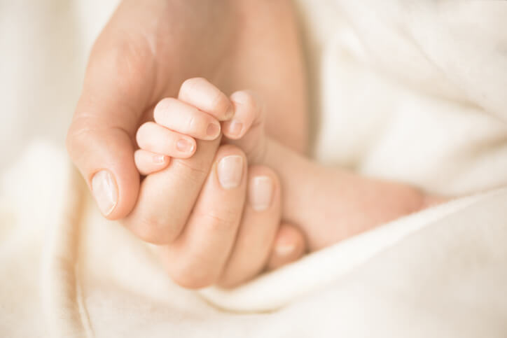 Griberefleksen - nyfødt baby griber om sin mors finger
