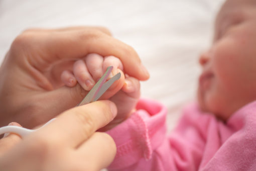 Baby får klippet negle med en babyneglesaks